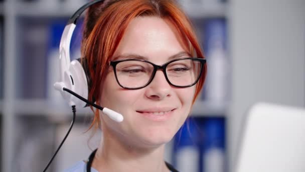Mosolygós Fiatal Női Orvos Szemüveges Beszélgetések Segítségével Fülhallgató Egy Hívást — Stock videók