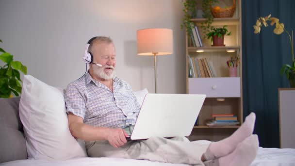 Modern Elderly Man Talking Video Conference Laptop Using Headset While — Stock Video