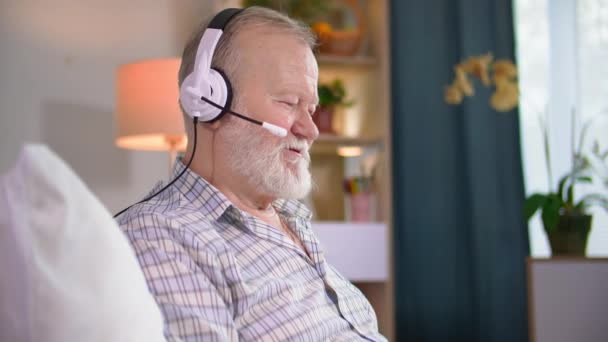 Pensionista Moderno Usando Auricular Hablando Través Videoconferencia Ordenador Portátil Mientras — Vídeos de Stock