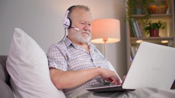 Çekici Yaşlı Bir Adam Yatak Odasındaki Kanepede Otururken Mikrofon Kulaklık — Stok video