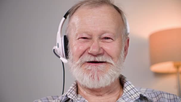 Портрет Пожилого Старика Микрофоном Наушниками Разговаривающего Видео Телефоне Ноутбуке Смотрящего — стоковое видео