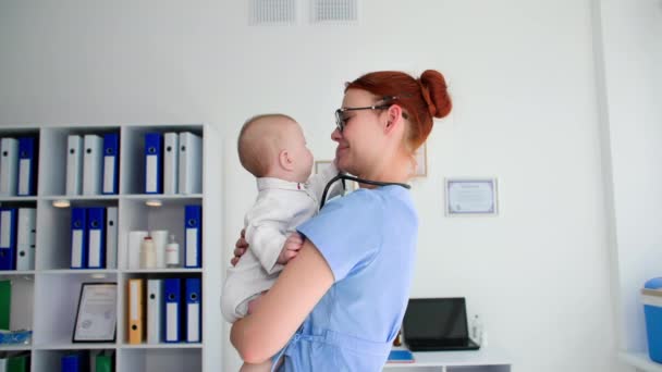 Çocuğun Sağlığıyla Ilgilenmek Kadın Doktor Küçük Şirin Çocuğu Kollarında Tutuyor — Stok video