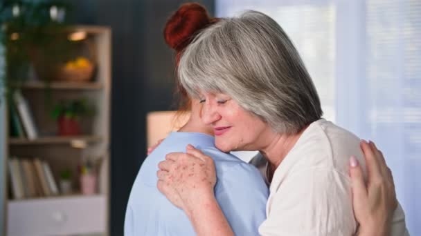 高齢者のサポートと慰め 高齢の女性は 医療ユニフォームで女性のソーシャルワーカーを抱擁 — ストック動画