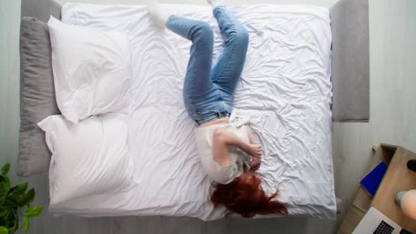 Молода Жінка Крутиться Ліжку Лежить Ногами Подушці Спальні Вид Зверху — стокове відео