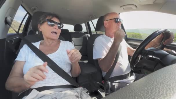 즐거운 퇴직자 행복한 노인들이 즐겁게 노래하고 차에서 추면서 여행하는 — 비디오
