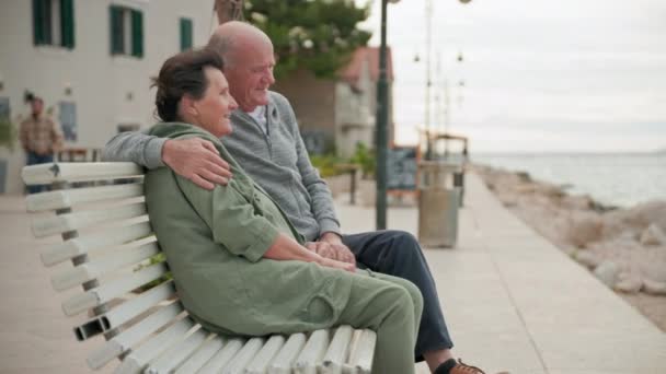 Happy Elderly Spouses Sit Embrace Bench Embankment Joint Vacation Sea — Stock Video