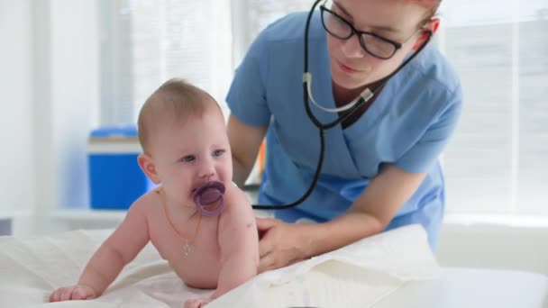 Gyermekorvos Aki Kisgyermeket Vizsgál Fonendoszkóppal Orvosi Rendelőben — Stock videók