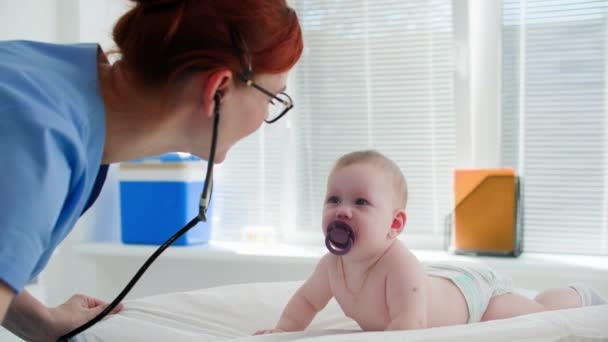 Παιδίατρος Νεαρή Γυναίκα Γιατρός Γυαλιά Εξετάζει Ένα Μικρό Παιδί Χυμό — Αρχείο Βίντεο