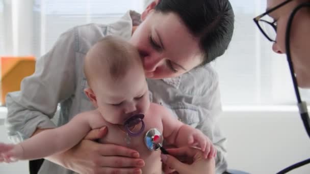 医学オフィスの診察で 小さな子供と幼い母親の診察 — ストック動画