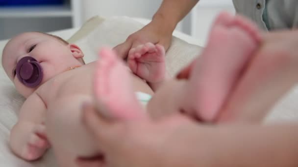 在医生诊所对婴儿进行体格检查时 女儿科医生将婴儿的小腿放在她的手中 — 图库视频影像