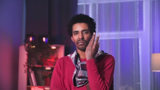 Jovem Homem Negro Tocando Seu Rosto Com Mãos Olhando Atenciosamente — Vídeo de Stock