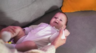 Bebeklik, küçük bebek emzirme, kanepede yatarken anne babasıyla oynaşmak.