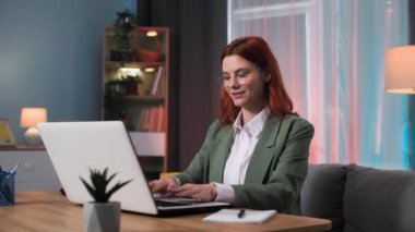 Modern teknoloji, gözlüklü kadın online alışveriş için dizüstü bilgisayar kullanıyor masada oturuyor.