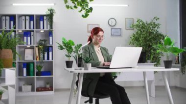 Çevre dostu ofis, vizyon gözlüğü takan kadın çalışan yeşil bitkilerle çalışıyor.