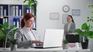 Çalışma ortamı, çevre dostu şirketin kadın çalışanları laptopta yeşil santrallerle çalışıyorlar.