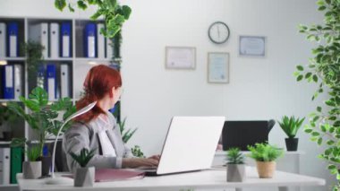 İş arkadaşları arasındaki ilişki, gülümseyen kadın çalışanların ofiste otururken kağıt atması.