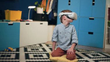 yenilikçi öğretim ve gelişim yöntemleri, VR gözlüklü modern küçük çocuk oyun oynuyor ya da modern teknolojileri kullanarak rahat bir odada otururken eğitimden geçiyor