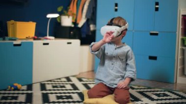 Çocuklar için modern oyunlar, gözlüklü küçük çocuk rahat bir odada sanal gerçeklik oyunları oynuyor.
