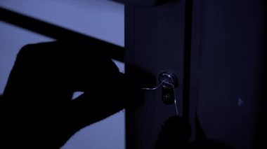 Tehlikeli suçlu ana anahtarlarla kapıyı açmaya çalışıyor.