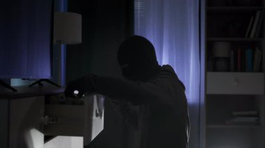 Soygun, kar maskeli şüpheli bir erkek gecenin geç saatlerinde etrafı karıştırıyor.