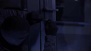İzinsiz giriş, eldivenli erkek hırsız kilitleri kullanarak kilitleri açmaya ve gece oda kapısını açmaya çalışıyor.