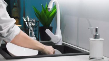 ev temizliği, ev hanımı sünger ve köpük tabakları mutfak lavabosunda, yakın plan.