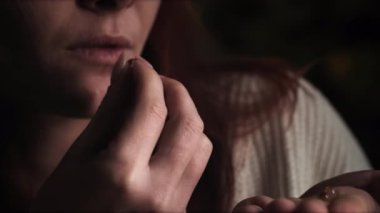 Genç bir kadının hap içip, cam bardaktan içmesini yakından izleyin.