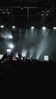 Ön planda, iki kadın parmaklarınızla yavaş maviye karşı kalp yapıyor, sonra da arka planda sahne ışığını yakıyorsunuz.