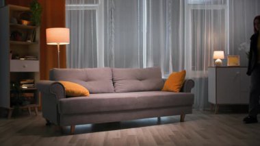 Akşamları işten sonra yorgun bir kadın, dış giysisi ve ayakkabılarıyla ceketini çıkarıp yere atar, yumuşak kanepeye düşer ve yüzünü oturma odasına, yastığa gömer.