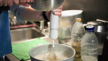 Krep hamurunu yoğururken, baba ve oğlu birlikte çalışırken, kuyunun beyaz mutfağına elek hamuru katıyorlar.