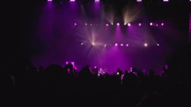 Renkli ve dinamik bir ışık gösterisi. Karanlık bir hayran silueti sahne ışıklarının arka planına karşı dalga benzeri bir hareketle el kaldırdı. Konser salonundaki tüm hayranlar bir flash mob organize ediyor.