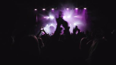 El sallayan hayranların karanlık silueti. Magenta sahne arkası gösterisi, hayranların en sevdiği rock grubu sahnede