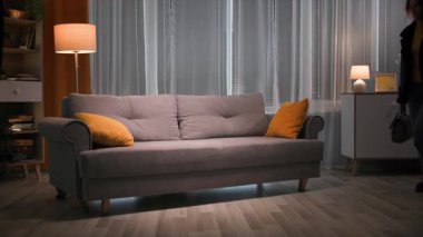 Akşamları, işten sonra giysi ve ayakkabılarla yorgun ve mutsuz bir kadın yumuşak kanepeye düşer ve yüzlerini sıcak, loş bir ışıkla yastığa gömer. 