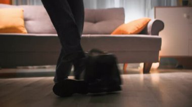 Kot pantolonlu bir kadın ayakkabılarını ve çantasını ayaklarıyla odanın her yerine atar. Kanepeye gidip dans ediyor. Oturma odasındaki arka planda, bacağının karanlık silueti sıcak.