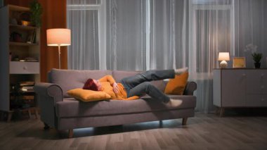 Çekimin başında, sarı kazaklı ve kot pantolonlu güzel kızıl saçlı bir kadın kanepede uzanıyor. Neşeli bir havası ve iyi duyguları var. Sonra ayağa kalktı, yastığı ayarladı ve...