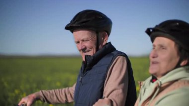 Emekli bir çift kır çiçeklerinin arasında yürüyor, adam bisiklete biniyor ve kadına sarılıyor, mutlular ve konuşuyorlar, birbirlerine eşlik ediyorlar ve vahşi manzaranın tadını çıkarıyorlar.