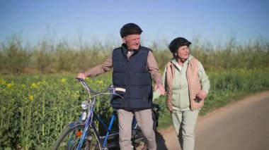 İki koltuklu bisikletten inen yaşlı bir çift kırsalda bir yol boyunca yavaşça yürür. Bir erkek ve bir kadın yan yana yürür ve gezi hakkındaki izlenimlerini tartışırlar.