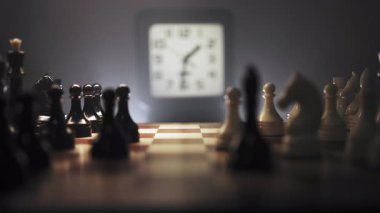 Bir insan ahşap bir satranç tahtasında satranç oynamaya derinden bağlıdır. Siyah ve beyaz satranç taşlarının karmaşık düzenini gösteren büyük yakın çekim. Oyuncunun eli parçaları hareket ettiriyor. Tahta.