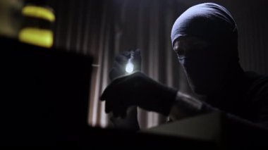 Elinde fener olan maskeli ve siyah giysili bir hırsız karanlık bir odada şifonyer çekmecesi açıyor. Elbiselerini çekmeceden çıkarıp değerli eşyalar arıyor. Değerli bir şey bulamayınca, adam geri döndü.