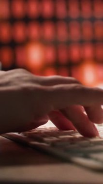 Kadın klavyeye yazı yazıp üstüne çay döküyor. Arka planda bir masa beyaz bir klavye ve bir monitör. Renk şeması, siyah ve beyaz aksanlı, kahverengi ve turuncu gibi sıcak tonları içerir.