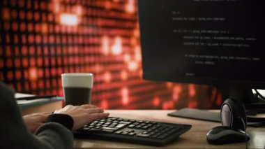 Bir kadın masada oturuyor ve bir bilgisayar klavyesine yazı yazıyor. Masanın üzerinde kadının periyodik olarak içtiği bir fincan kahve var. Odak noktası kişi ve klavye. Renk şeması