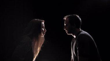 Loş bir odada, yüz yüze oturan bir erkek ve bir kadın, vücutları birbirine yakın. Yaklaştıktan sonra kadın sessiz bir jest yapıyor. İki insan arasındaki en samimi an odak noktasıdır.