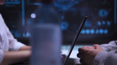 Bir kadın ve bir erkek yüksek teknoloji ofisindeki bir masada karşılıklı oturuyorlar. Kadın dizüstü bilgisayarında yazı yazıyor, sonra da önünü kapatıp adamla konuşmaya devam ediyor. Masa...