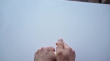 Adam elleriyle masadan bir parça hamur alıyor, yukarı fırlatıyor, sonra onu beyaz mutfak masasına geri atıyor ve yoğurmaya başlıyor. Erkek ellerindeki ilk kişiden en iyi görüntü. Büyük