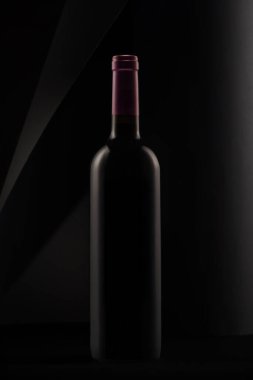 siyah bir arka plan üzerinde kırmızı şarap şişe