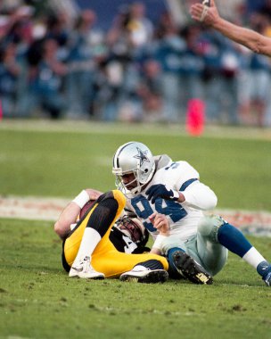 Dallas Cowboys defensive lineman Charles Haley looks at Pittsburgh Steelers QB Neil O'Donnell after sacking him during Super Bowl XXX played on January 28, 1996, in Tempe, Arizona. clipart