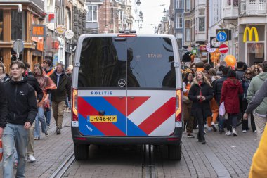 Kingsday, Amsterdam 'daki kalabalığın içinde polis arabası 27-4-2023