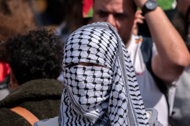 Keffiyeh Şallı Adam UVA Üniversitesi Amsterdam 'daki öğrenci gösterisinde yüzünü gizliyor. Hollanda 7-5-2024