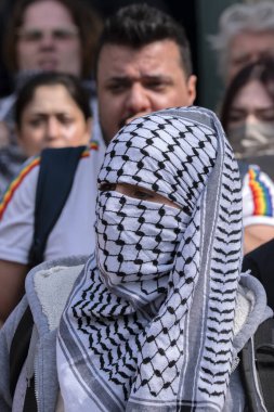 Keffiyeh Şallı Adam UVA Üniversitesi Amsterdam 'daki öğrenci gösterisinde yüzünü gizliyor. Hollanda 7-5-2024