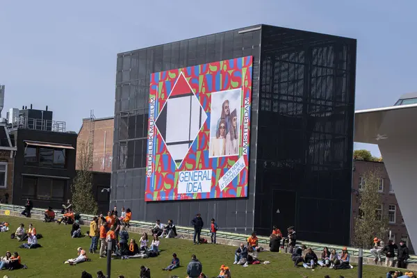 stock image Billboard Stedelijk Museum General Idea Exhibition And People Enjoying The Sun At Kindsday At Amsterdam The Netherlands 27-4-2023